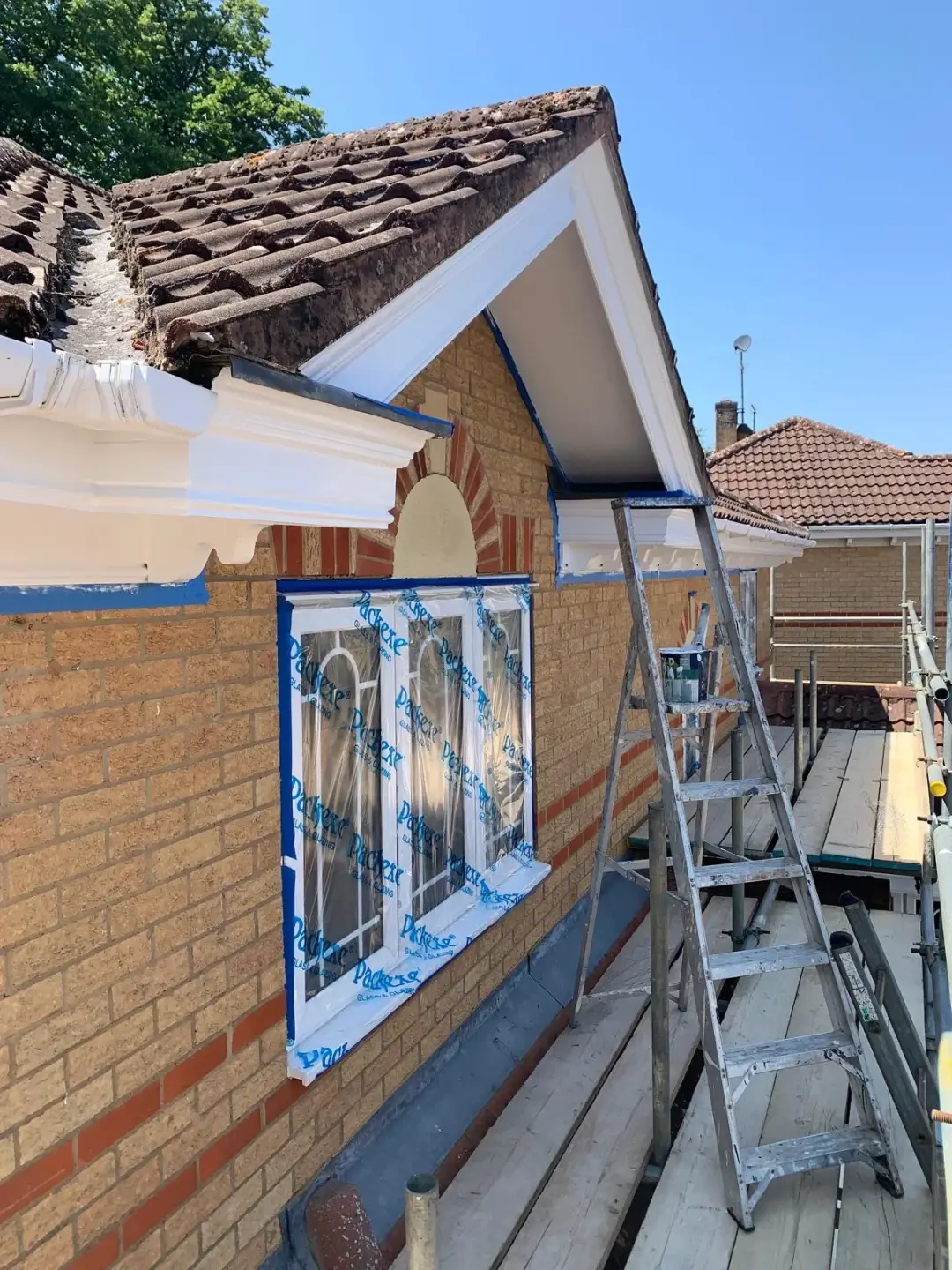 Terry Arthur’s Google review photo showing roofline woodwork being painted, with windows protected